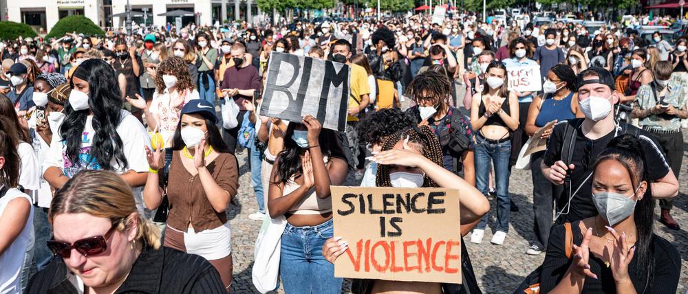 Teilnehmer einer Demonstration unter dem Motto ´Black lives still matter» stehen mit Schildern mit der Aufschrift ´BLM» und ´Silence is Violence» auf dem Pariser Platz. 