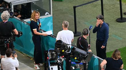Nächste Frage, Basti. Jessy Wellmer und Bastian Schweinsteiger. Joachim Löw (Mitte) hört zu. 