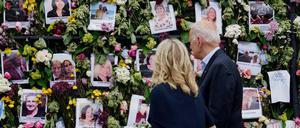 Joe und Jill Biden betrachten eine mit Blumen und Fotos der Vermissten bedeckte Gedenkwand.