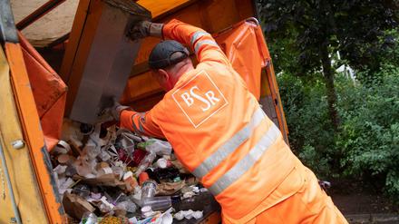 BSR-Mitarbeiter Thomas Jardke entleert Mülleimer im Weinbergpark. Ramona Pop (Bündnis 90/Die Grünen), Senatorin für Wirtschaft, Energie und Betriebe in Berlin sowie BSR-Aufsichtsratsvorsitzende besuchte Mitarbeiter der Berliner Stadtreinigung (BSR) bei deren Arbeiten im Park.