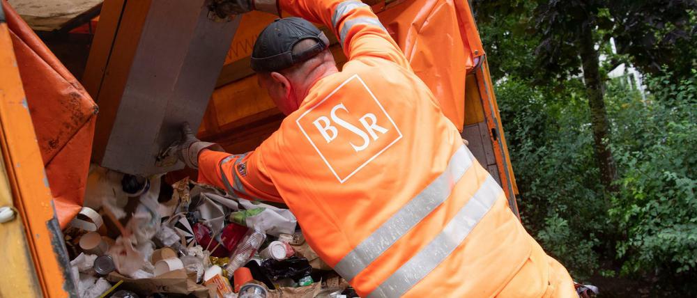 BSR-Mitarbeiter Thomas Jardke entleert Mülleimer im Weinbergpark. Ramona Pop (Bündnis 90/Die Grünen), Senatorin für Wirtschaft, Energie und Betriebe in Berlin sowie BSR-Aufsichtsratsvorsitzende besuchte Mitarbeiter der Berliner Stadtreinigung (BSR) bei deren Arbeiten im Park.