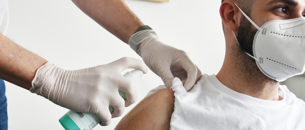 Ein Hausarzt impft einen Patienten in Schöneberg mit Astrazeneca. 