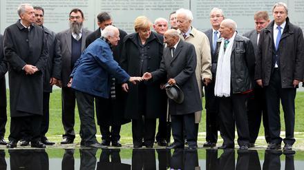 Tag der Einweihung: In Gegenwart der Kanzlerin reichen sich Dani Karavan (links) und ein Überlebender des NS-Völkermords an den Sinti und Roma vor dem neuen Mahnmal die Hände.