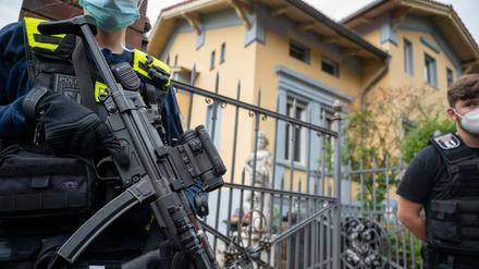 Schwer bewaffnete Polizisten stehen vor der Remmo-Villa in Alt-Buckow.