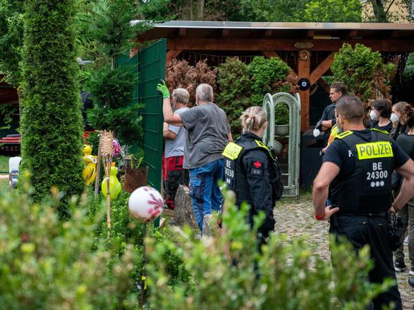 Unter Polizeischutz: Arbeiter errichten einen Zaun zwischen den beiden Grundstücken.