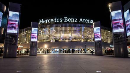 Die hell erleuchtete Mercedes-Benz Arena bei Nacht.