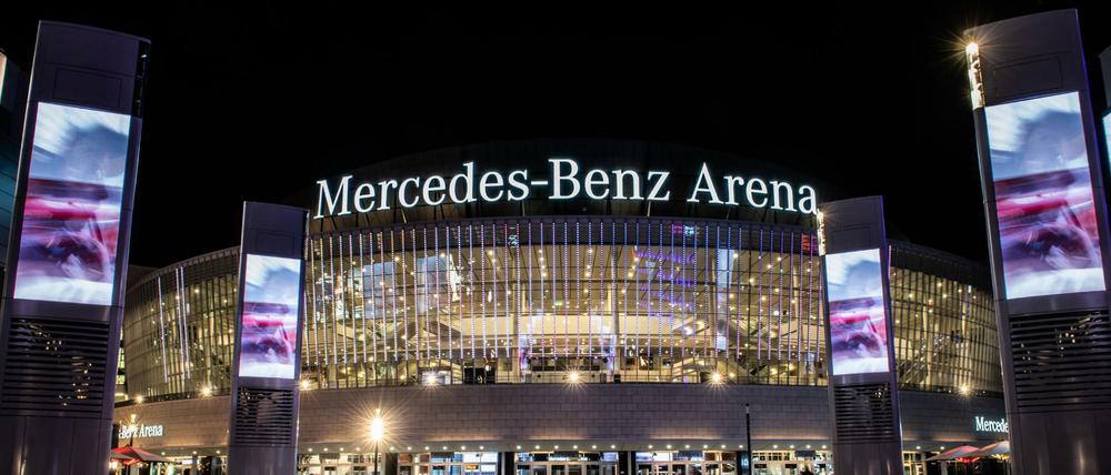 Die hell erleuchtete Mercedes-Benz Arena bei Nacht.