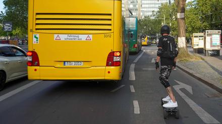 Groß- neben Kleinstfahrzeug: Auf dem Elektro-Skateboard im Berliner Straßenverkehr.