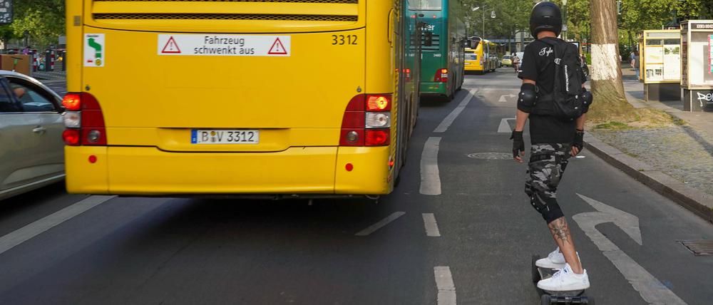 Groß- neben Kleinstfahrzeug: Auf dem Elektro-Skateboard im Berliner Straßenverkehr.