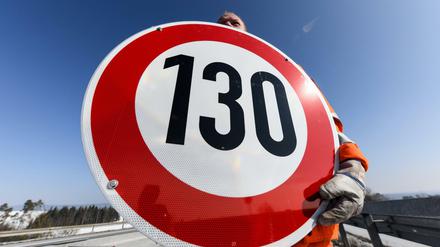 Ein Tempolimit-Zeichen wird an einer Autobahn angebracht.