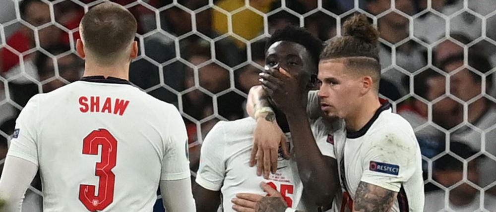 Mitspieler trösten Bukayo Saka nach dem verschossenen Elfmeter. 