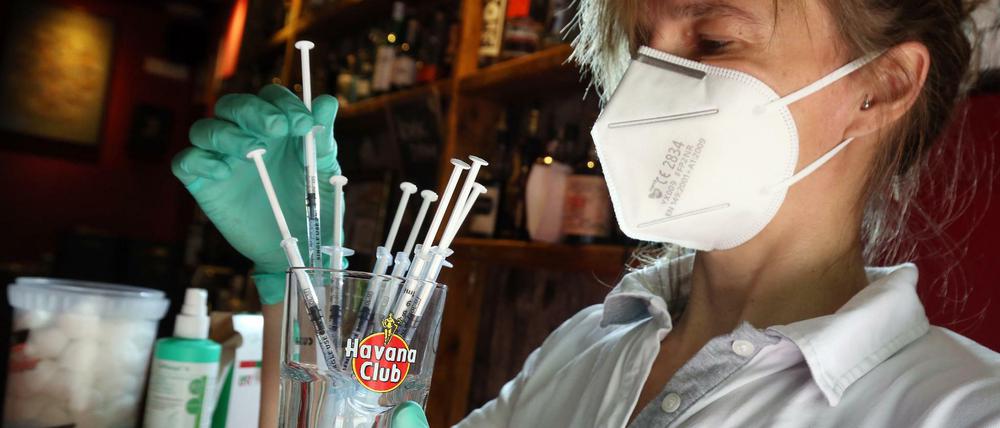 Eine medizinische Fachangestellte sortiert in der Revolte-Bar im Berliner Bezirk Friedrichshain Spritzen mit dem Impfstoff Johnson &amp; Johnson 