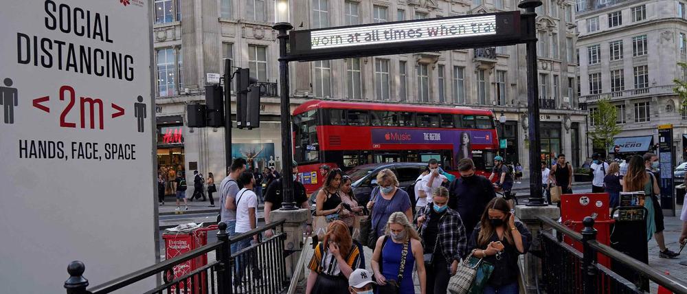 Pendler, die aufgrund von Covid-19 Gesichtsbedeckungen tragen, betreten am 7. Juni 2021 die Londoner U-Bahn-Station Oxford Circus im Zentrum von London.