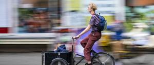 In einer Sänfte durch Neukölln wie früher die Könige: Immer mehr Eltern setzen sich für ihr Kind aufs Lastenrad.