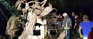 Rettungskräfte stehen neben dem ausgebrannten Kleinbus.