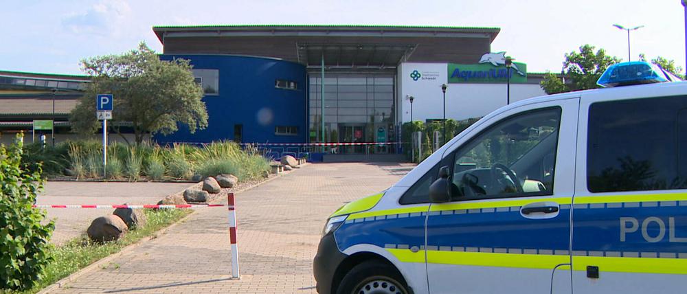 Ein Polizeiauto steht vor der Schwimmhalle in Schwedt. 