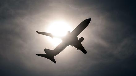 Ein Flugzeug startet vom Flughafen in Düsseldorf und fliegt an der Sonne vorbei. (Symbolbild)