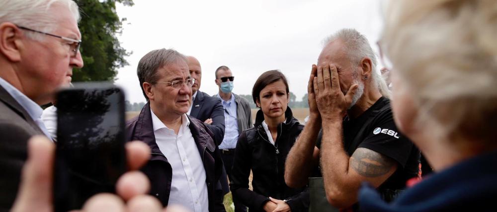 Bundespräsident Frank-Walter Steinmeier (l.) und Ministerpräsident Armin Laschet sprechen mit Hinterbliebenen in Erftstadt.