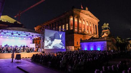 Menschen verfolgen im Kolonnadenhof auf der Museumsinsel den Auftakt der Ufa-Filmnächte im Sommer 2017.