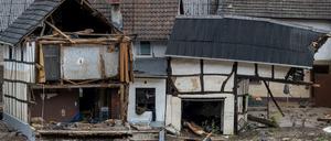 Schutt liegt in dem Ort im Kreis Ahrweiler nach dem Unwetter mit Hochwasser vor einem beschädigten Gebäude.