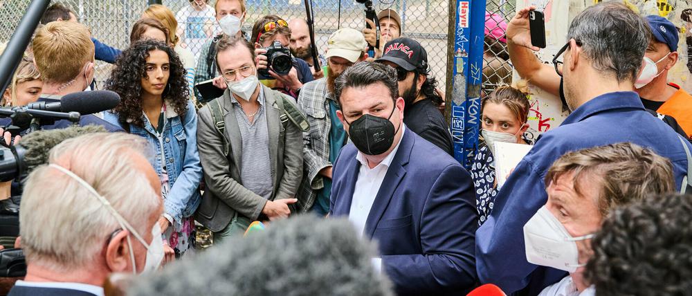 Hubertus Heil (SPD, Mitte), Bundesminister für Arbeit und Soziales, hört den Beschäftigten des Lieferdienstes Gorillas auf dem Lausitzer Platz zu.