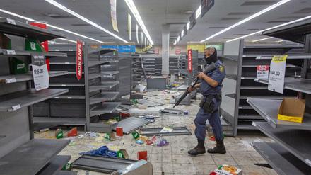 Ein Polizist geht durch ein geplündertes Geschäft in Johannesburg.
