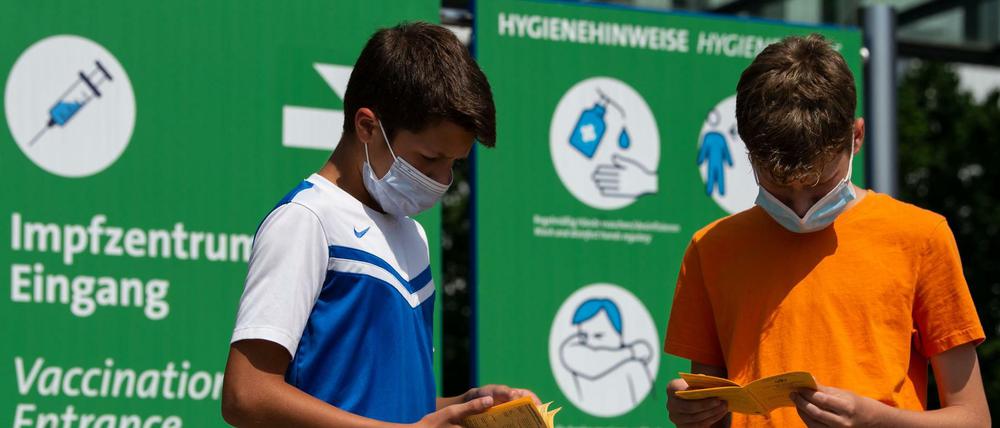 Impfen - eine Frage der Solidarität? Die Geschwister-Impflinge Hugo (12 Jahre) und Urs (13 Jahre) blättern vor ihrer Impfung am Impfzentrum in ihren Impfbüchern.