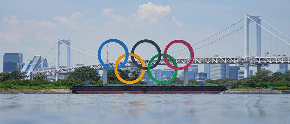 Ein Blick auf olympischen Ringe vor der Rainbow Bridge. Die Ringe stehen auf einem Ponton in der Bucht von Tokio.