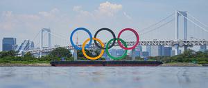 Ein Blick auf olympischen Ringe vor der Rainbow Bridge. Die Ringe stehen auf einem Ponton in der Bucht von Tokio.