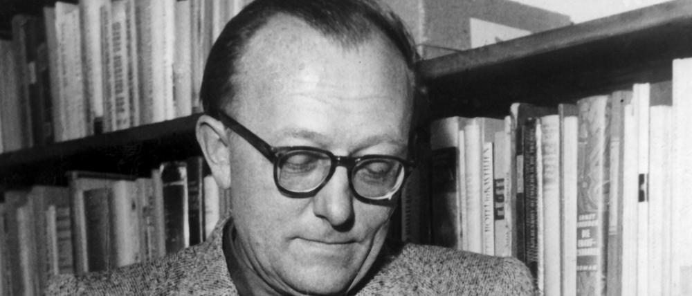 Günther Eich blättert in einem Buch. 1953.