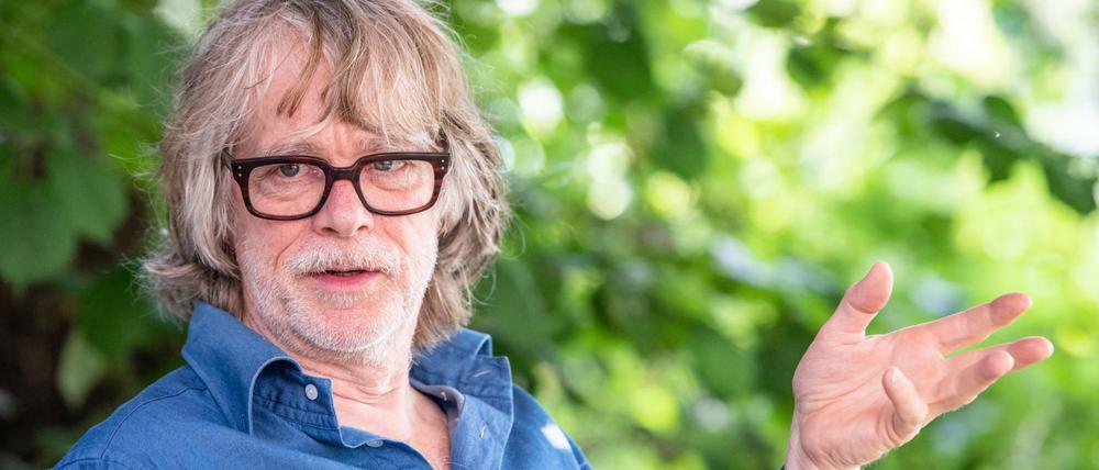 Helge Schneider, Musiker, spricht in seinem Garten mit einem Journalisten.
