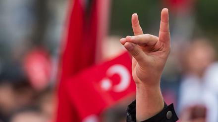 Eine Mann zeigt den "Wolfsgruß" der türkischen Grauen Wölfe auf einer Kundgebung in München.