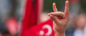 Eine Mann zeigt den "Wolfsgruß" der türkischen Grauen Wölfe auf einer Kundgebung in München.