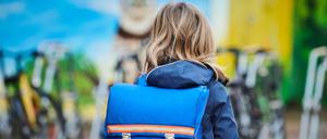 Ein Schüler steht mit Schulranzen über den Schulhof einer Grundschule in Prenzlauer Berg. (Symbolbild)