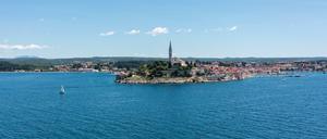 Ein Boot segelt im adriatischen Meer vor dem malerischen kroatischen Touristenort Rovinj. 