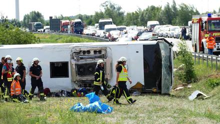 Rettungskräfte sind an der Unfallstelle im Einsatz. Der Reisebus war auf der A13 bei Schönwald südöstlich von Berlin verunglückt. 