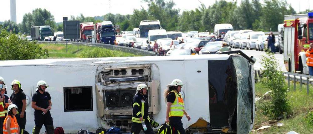 Rettungskräfte sind an der Unfallstelle im Einsatz. Der Reisebus war auf der A13 bei Schönwald südöstlich von Berlin verunglückt.