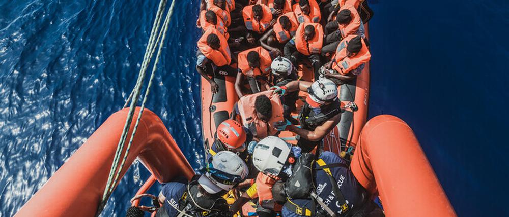 Gerettete Migranten sitzen in einem Schlauchboot der Rettungsorganisation "Ocean Viking".