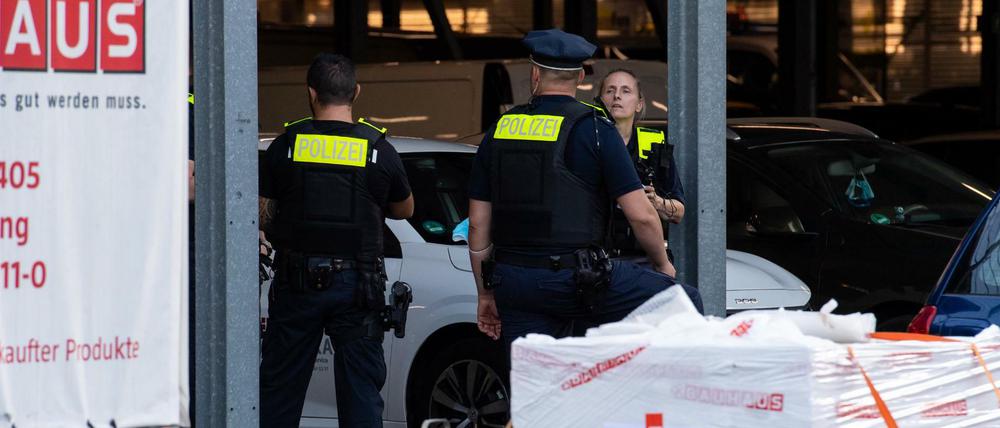 Polizisten stehen hinter Absperrbändern auf dem Gelände eines Baumarktes in Berlin-Wedding.