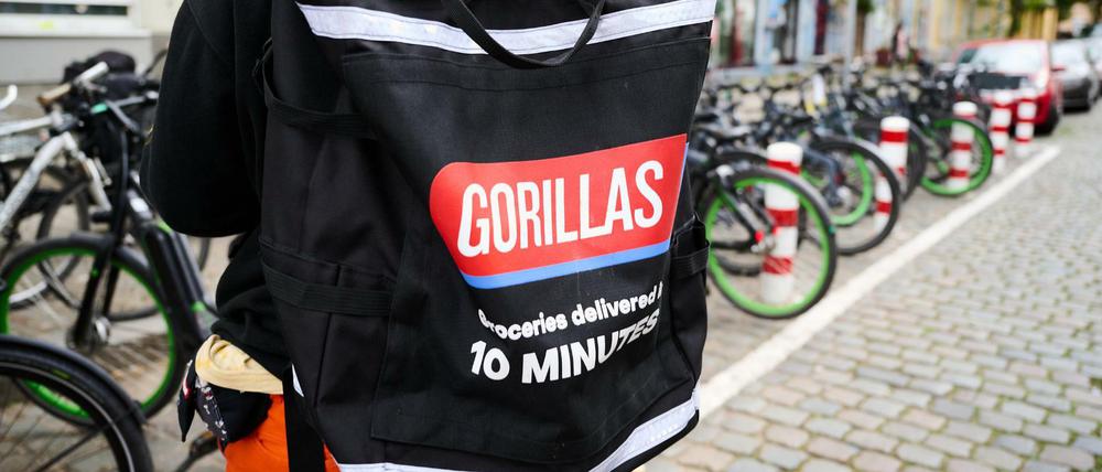 Ein Beschäftigter des Lieferdienstes Gorillas trägt einen Rucksack und steht vor den Fahrrädern. Die Fahrer demonstrieren seit Wochen gegen die Arbeitsbedingungen bei dem jungen Start-Up.