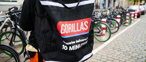Ein Beschäftigter des Lieferdienstes Gorillas trägt einen Rucksack und steht vor den Fahrrädern. Die Fahrer demonstrieren seit Wochen gegen die Arbeitsbedingungen bei dem jungen Start-Up.