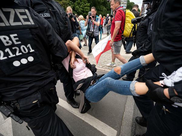 Die Polizei nimmt eine Demonstrantin bei einer unangemeldeten Demonstration an der Siegessäule fest.