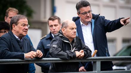 Armin Laschet (CDU, l-r), Ministerpräsident von Nordrhein-Westfalen, Olaf Scholz (SPD), Bundesfinanzminister, und Tim Grüttemeier (CDU), Städteregionsrat der Städteregion Aachen, stehen auf einer Brücke über dem Vichtbach.