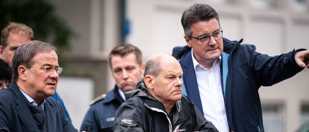 Armin Laschet (CDU, l-r), Ministerpräsident von Nordrhein-Westfalen, Olaf Scholz (SPD), Bundesfinanzminister, und Tim Grüttemeier (CDU), Städteregionsrat der Städteregion Aachen, stehen auf einer Brücke über dem Vichtbach.