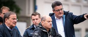 Armin Laschet (CDU, l-r), Ministerpräsident von Nordrhein-Westfalen, Olaf Scholz (SPD), Bundesfinanzminister, und Tim Grüttemeier (CDU), Städteregionsrat der Städteregion Aachen, stehen auf einer Brücke über dem Vichtbach.