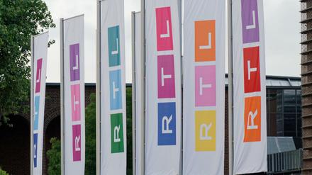 Fahnen des Fernsehsenders RTL stehen auf dem Platz vor dem Firmengebäude in Köln.