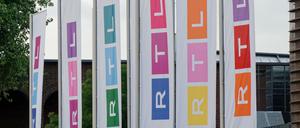 Fahnen des Fernsehsenders RTL stehen auf dem Platz vor dem Firmengebäude in Köln.