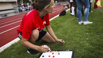 Berliner Fußballtrainerin Carmen Grimm mit Taktiktafel an der Seitenlinie.