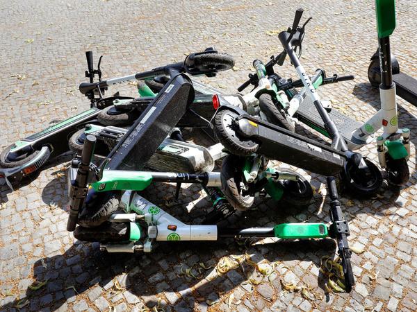 Umgestürzte E-Roller liegen auf einem Gehweg in Berlin.
