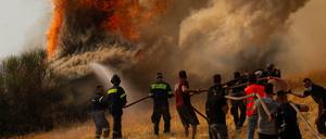 Feuerwehrleute und Freiwillige versuchen ein Feuer in Afidnes, etwa 30 Kilometer von der griechischen Hauptstadt Athen entfernt, zu löschen.